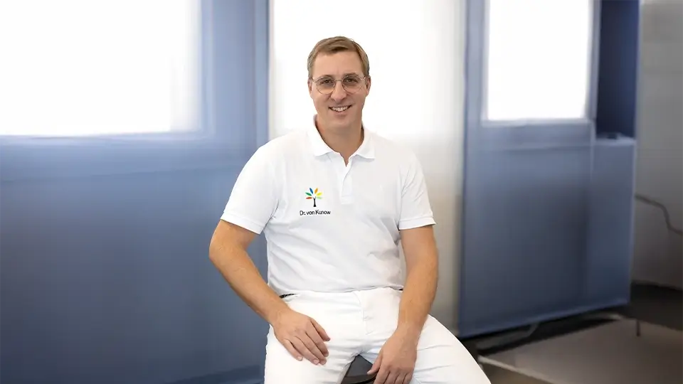 Porträt von Dr. Frederik von Kunow – Facharzt für Orthopädie sitzend in einem Behandlungsraum